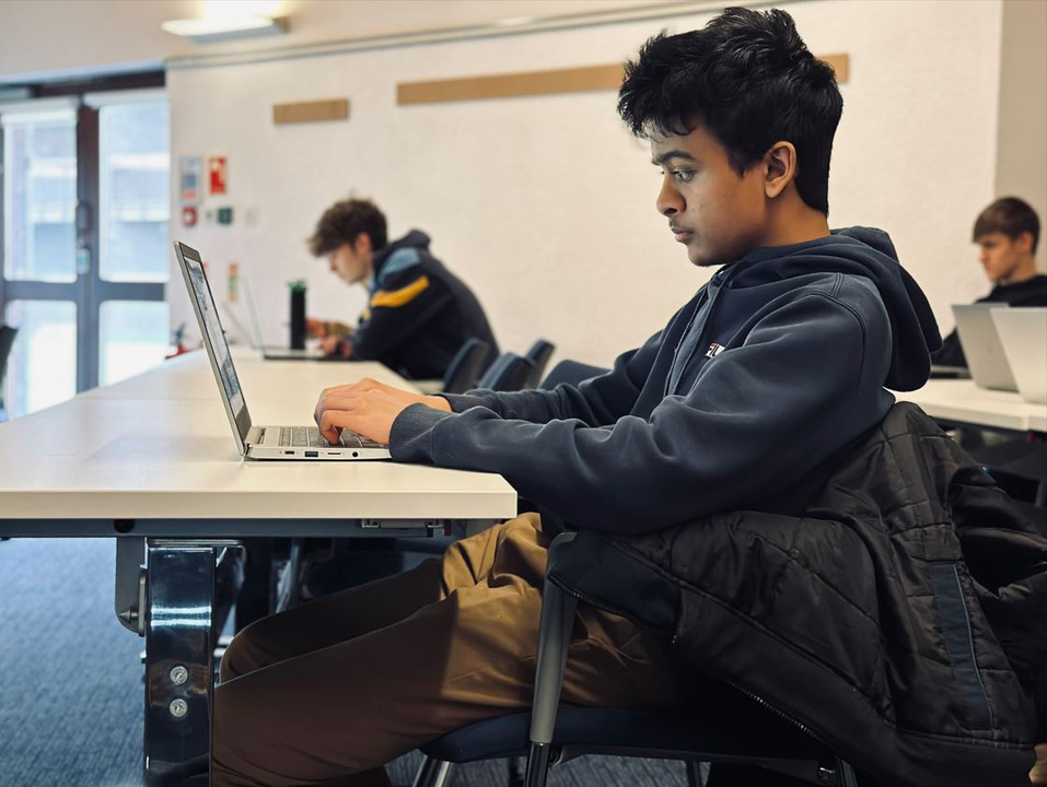 Student sitting looking at his laptop.