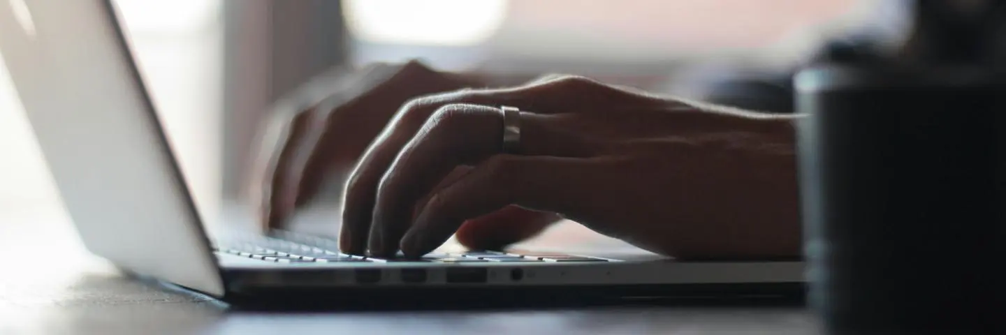 Close up of a person typing on a laptop