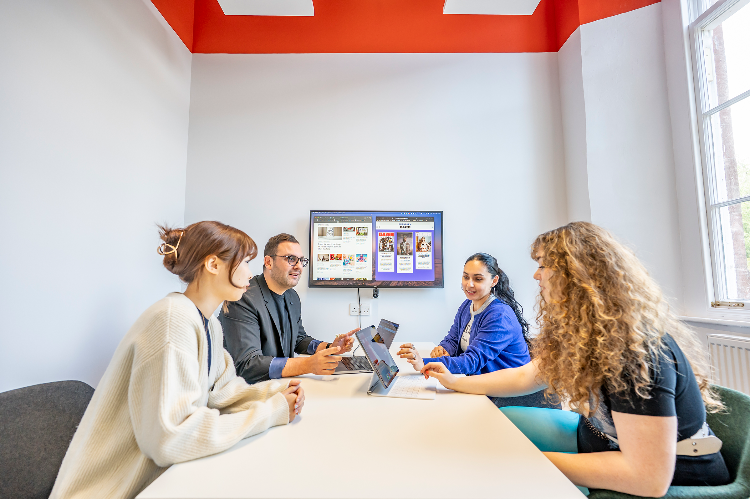 Four students use the quiet meeting room in the Learning Commons