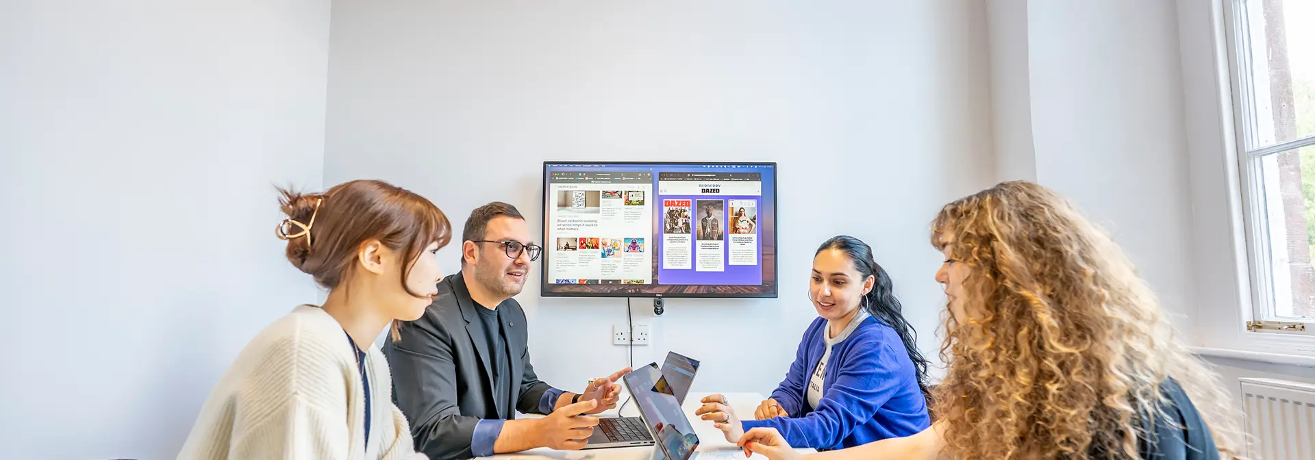 Four students use the quiet meeting room in the Learning Commons