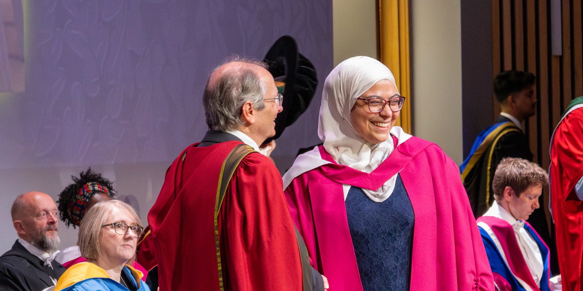 A PhD graduate receives her graduation certificate at the graduation ceremony.