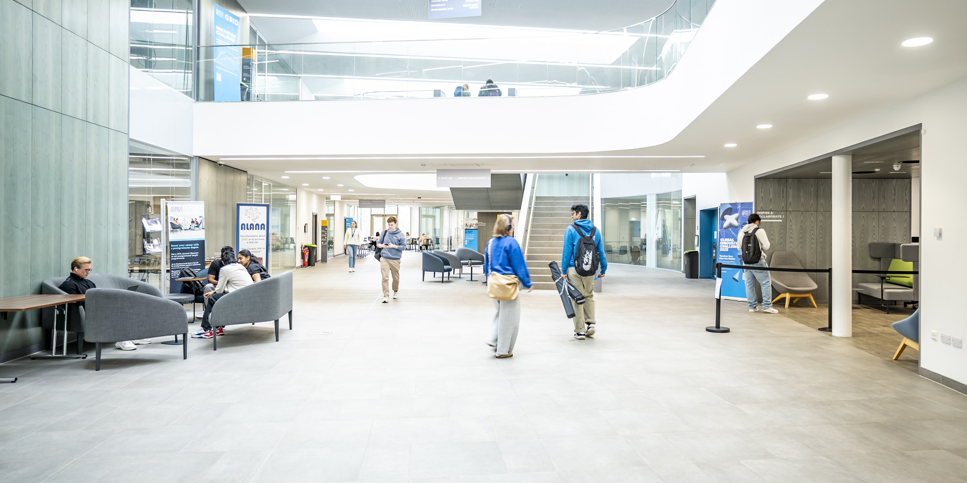 Students chat in the brightly lit GRID building foyer.