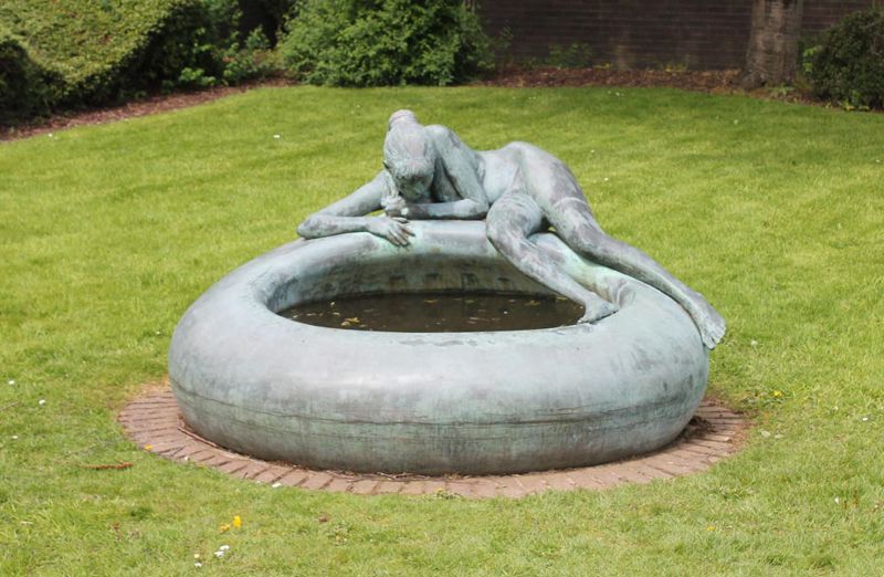 Bronze sculpture of a girl by a pool