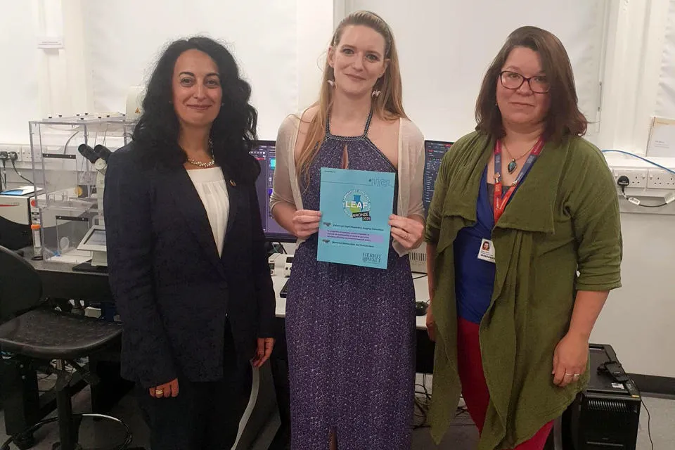 Presentation of the first LEAF certificate by Professor Mercedes Maroto-Valer, Deputy Principal for Global Environmental Sustainability and Anna Clark, Sustainability Strategy Coordinator, to ESRIC Facility Manager, Jessica Valli Professor Mercedes Maroto-Valer, Jessica Valli holding the LEAF award, and Anna Clark