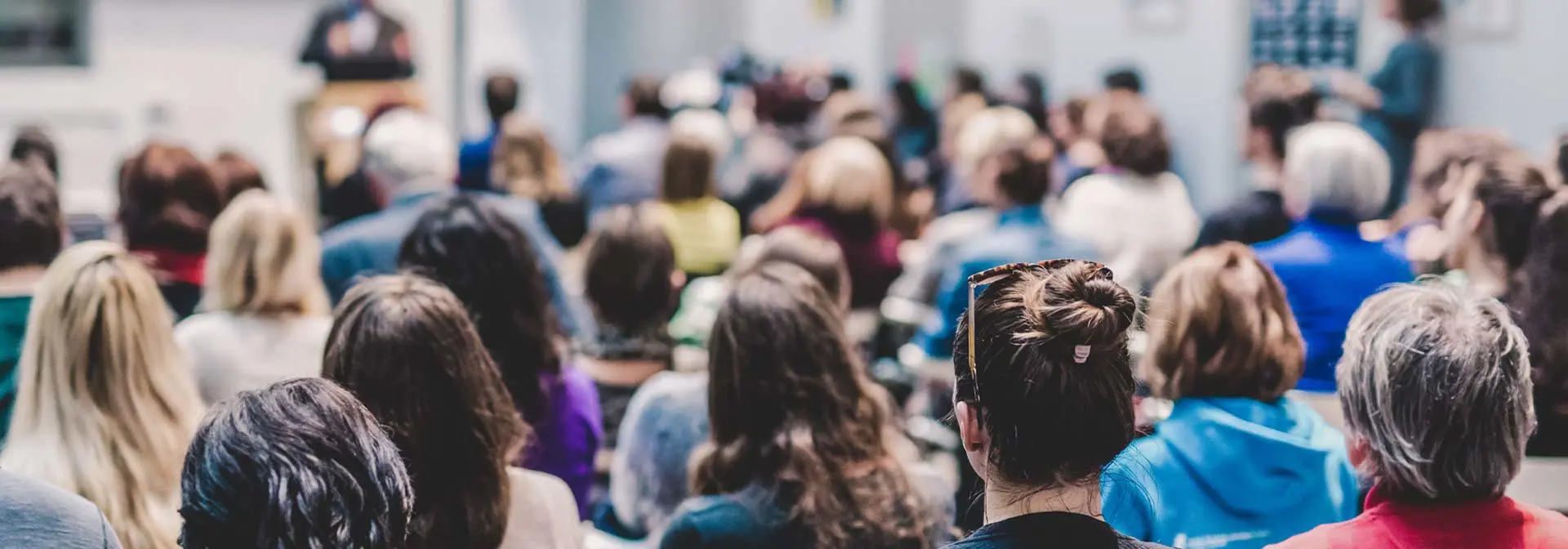 Crowd of people sitting in attendance at an event.