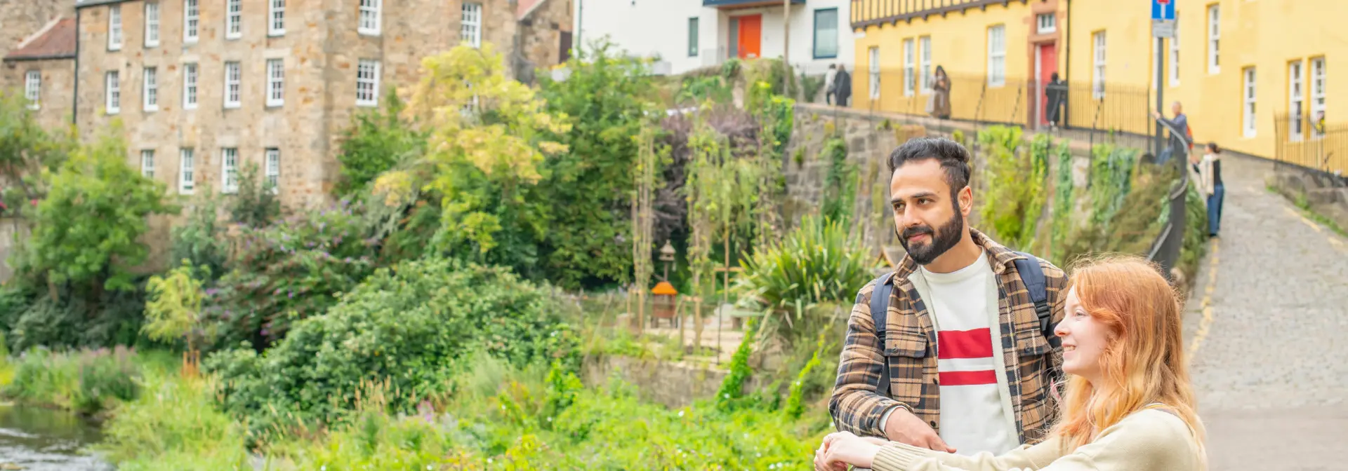 Two individuals standing by a fence in a village.