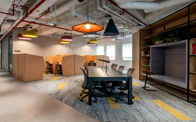 desks, individual pods and shelf with seating in the middle