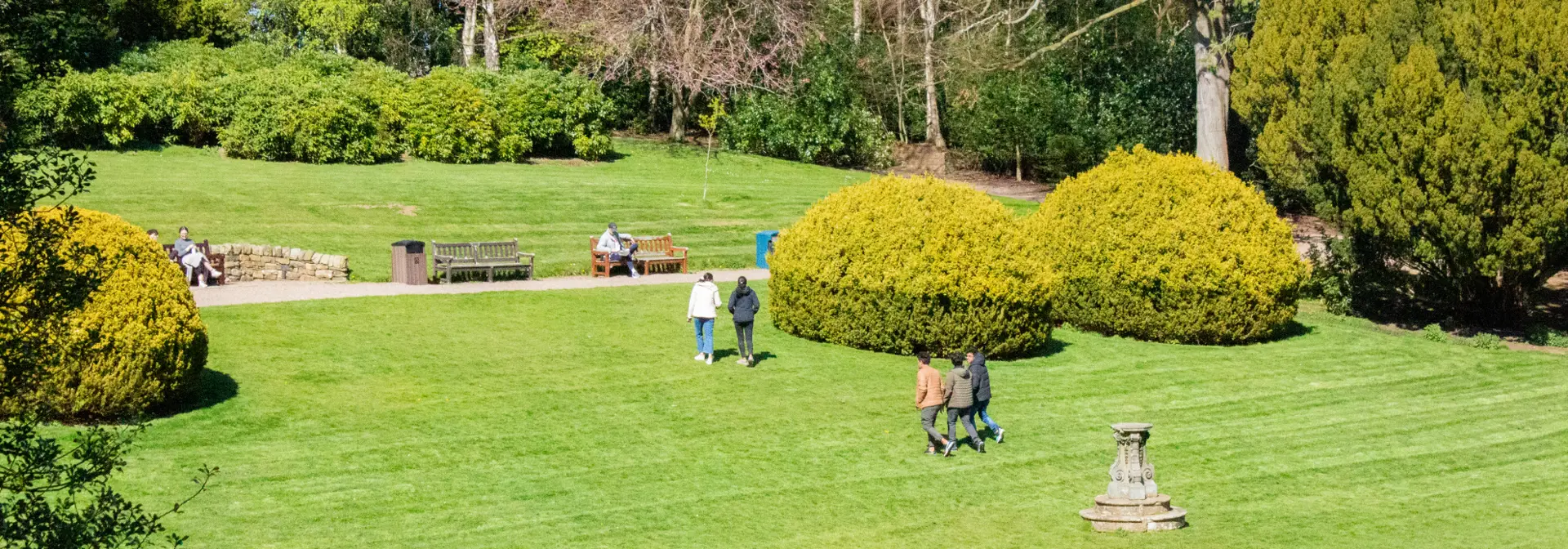 Students walking across a lawn on a sunny day.