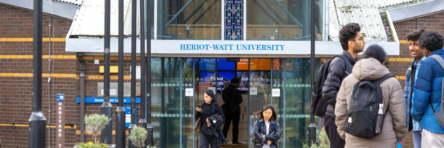 Individuals standing at an entrance to a building.