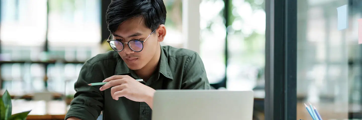Student works on a laptop reviewing documents.