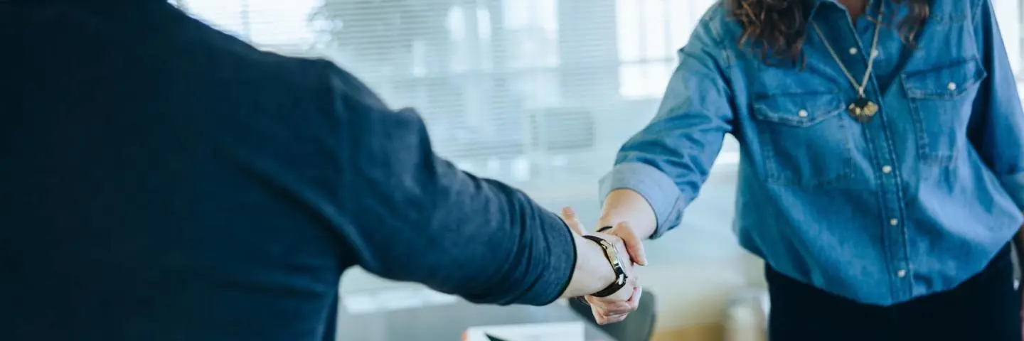 Two people meet and shaking hands.
