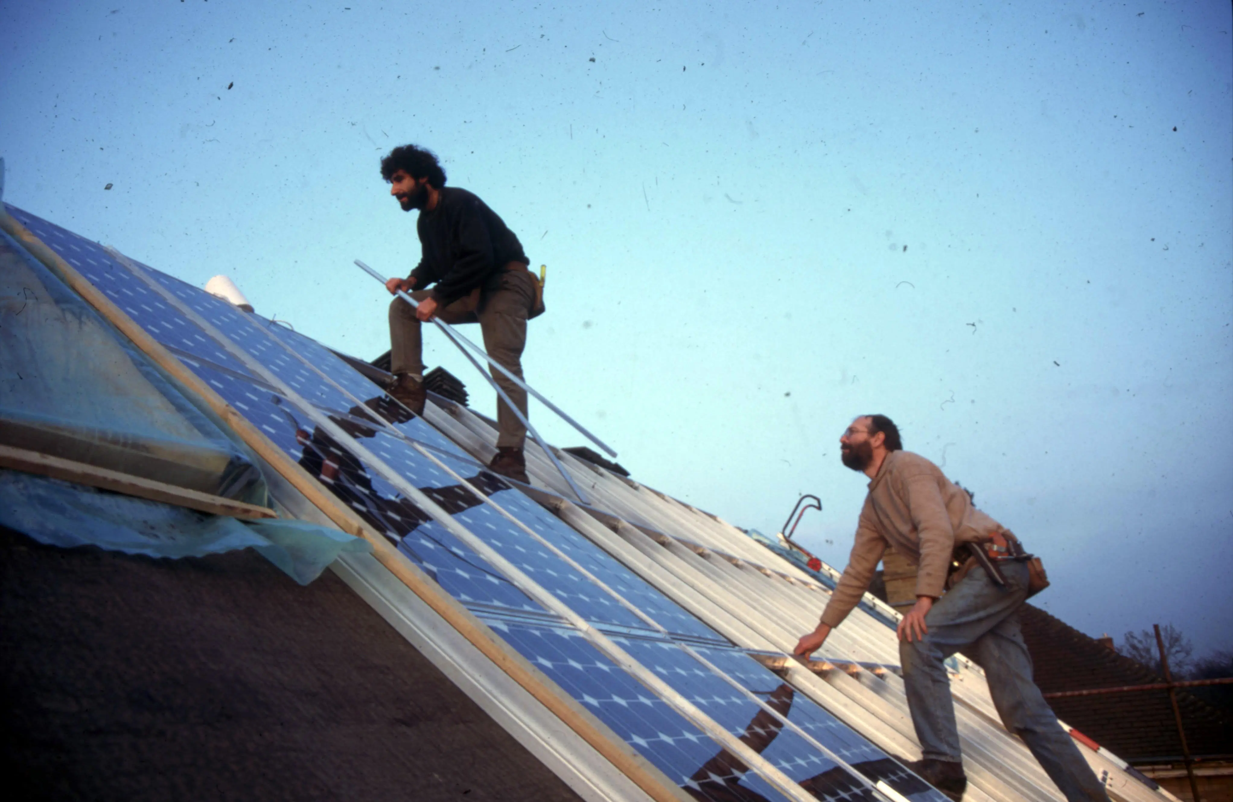 Image shows two workmen working on the solar roof 30 years ago. 