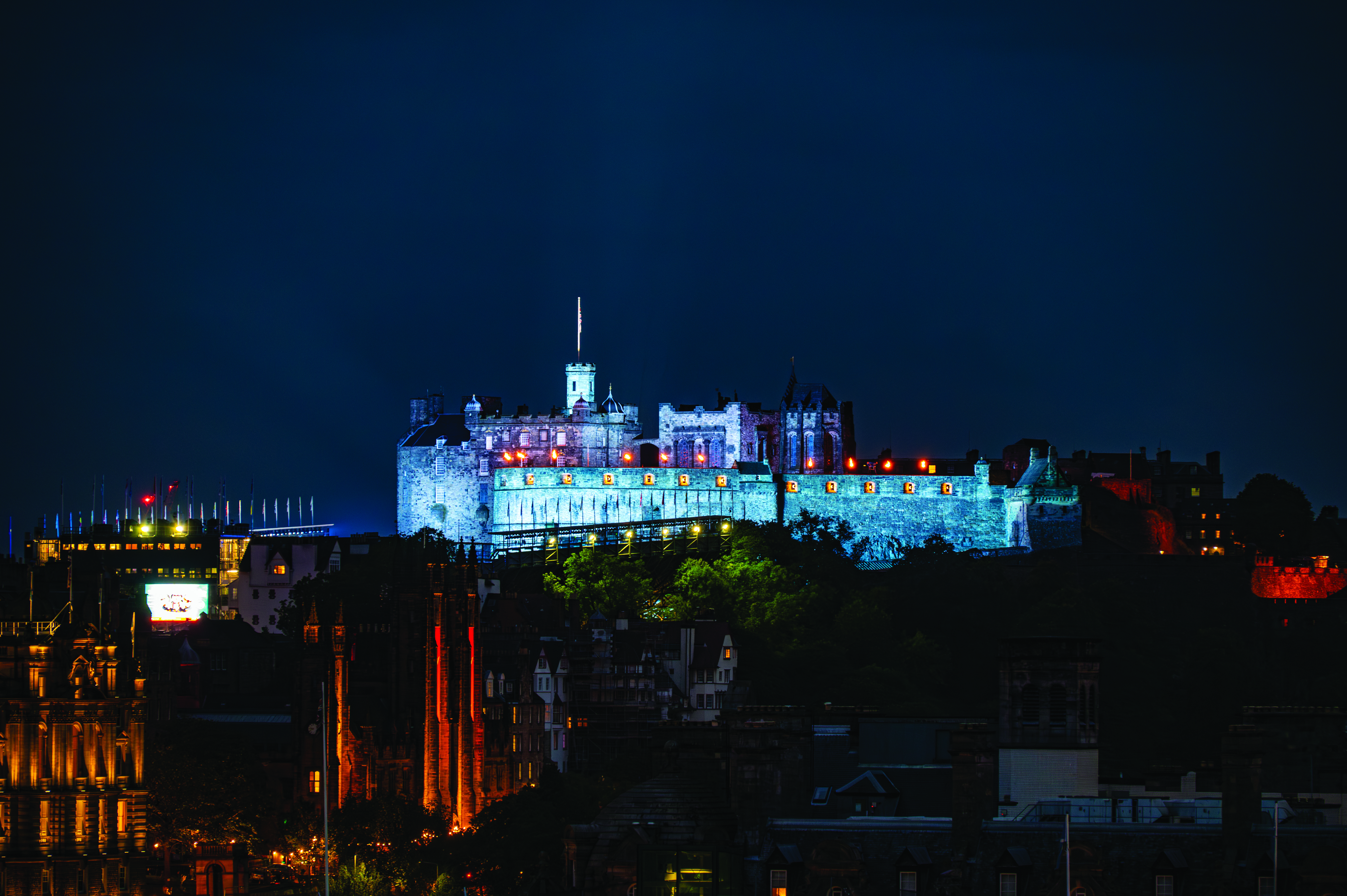 Long distance photo of Edinburgh Castle lit up at nightime.