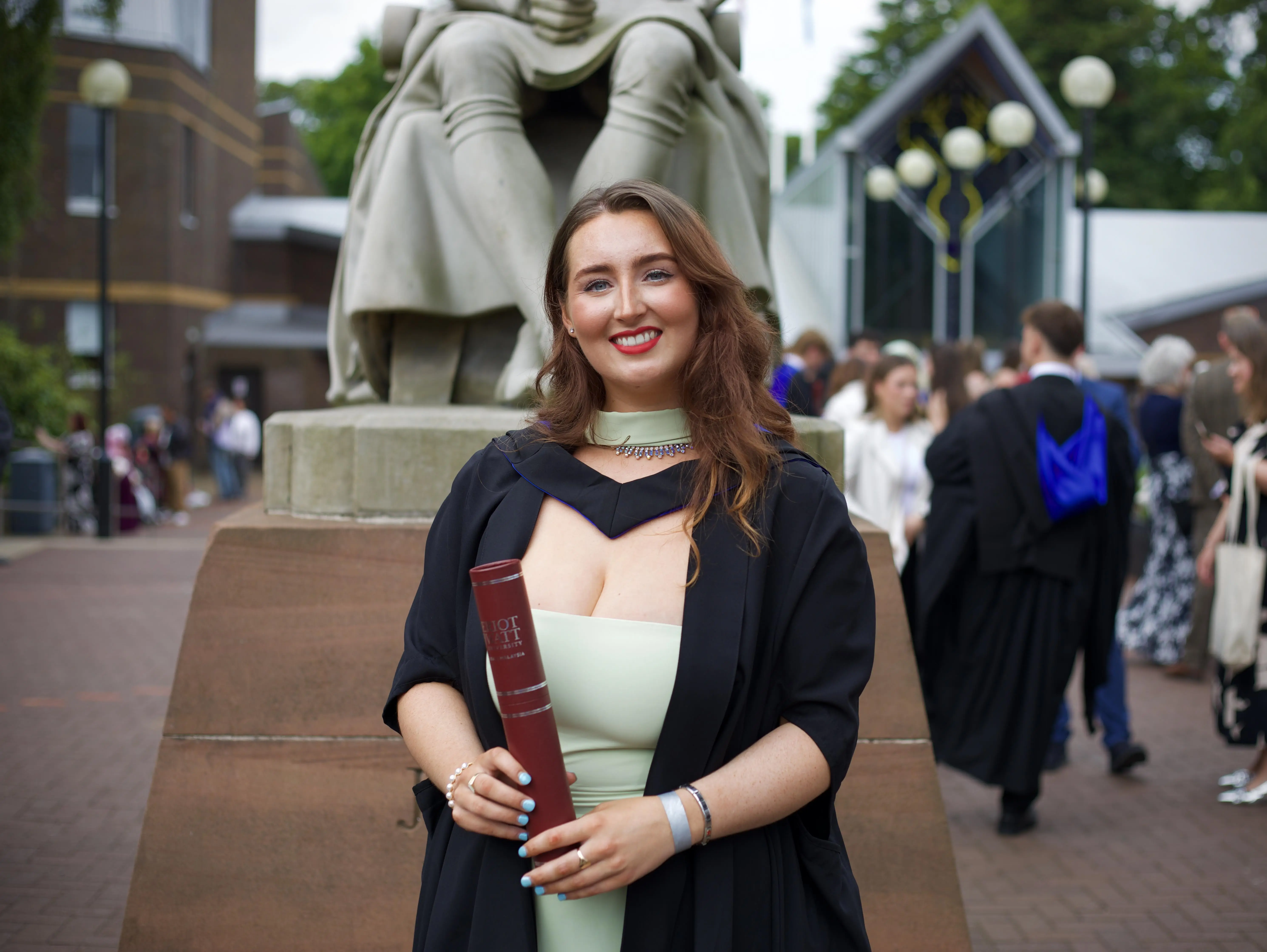 Picture of Caitlin Cummings standing with her scroll.