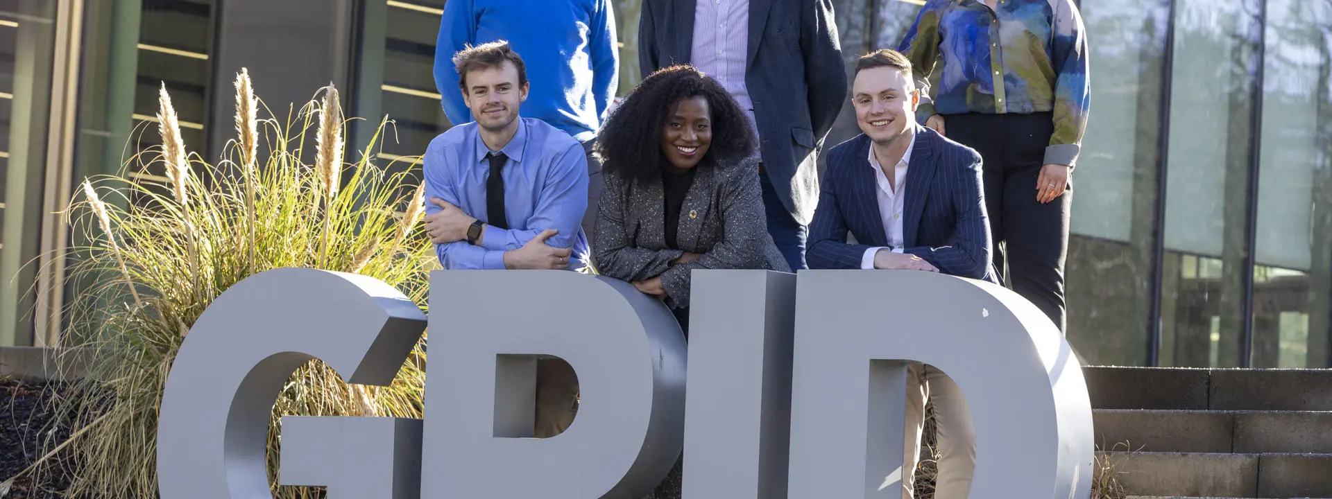 Heriot-Watt and CGI stakeholders stand behind the university's Heriot-Watt's Global Research Innovation Discovery sign