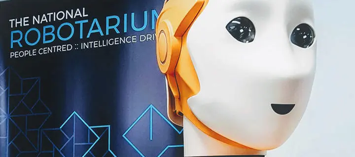 A robot beside a banner for the National Robotarium