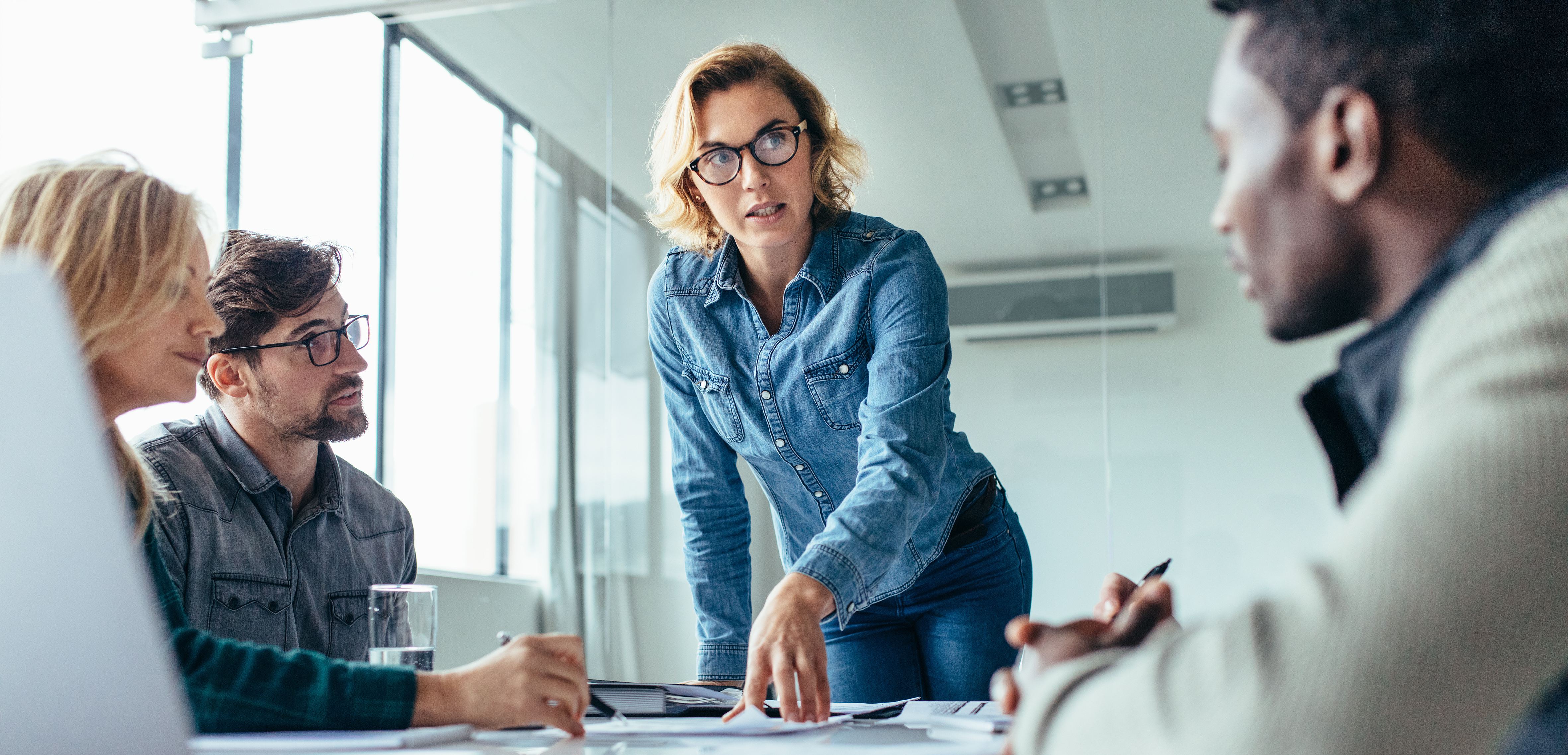 Woman at desk explaining business information.