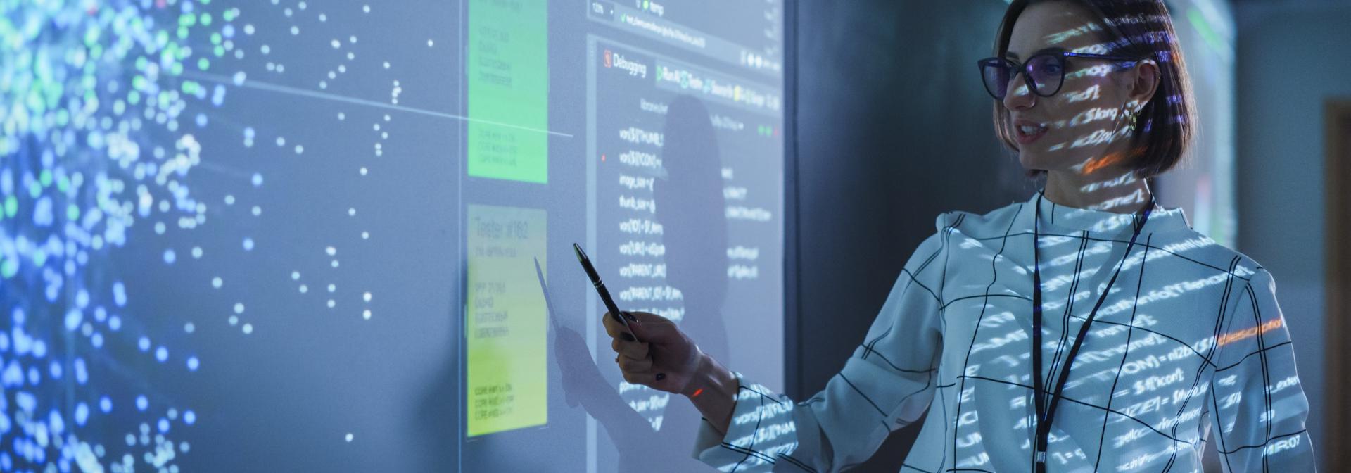 Female data scientist showcasing their data visualisation on a projector