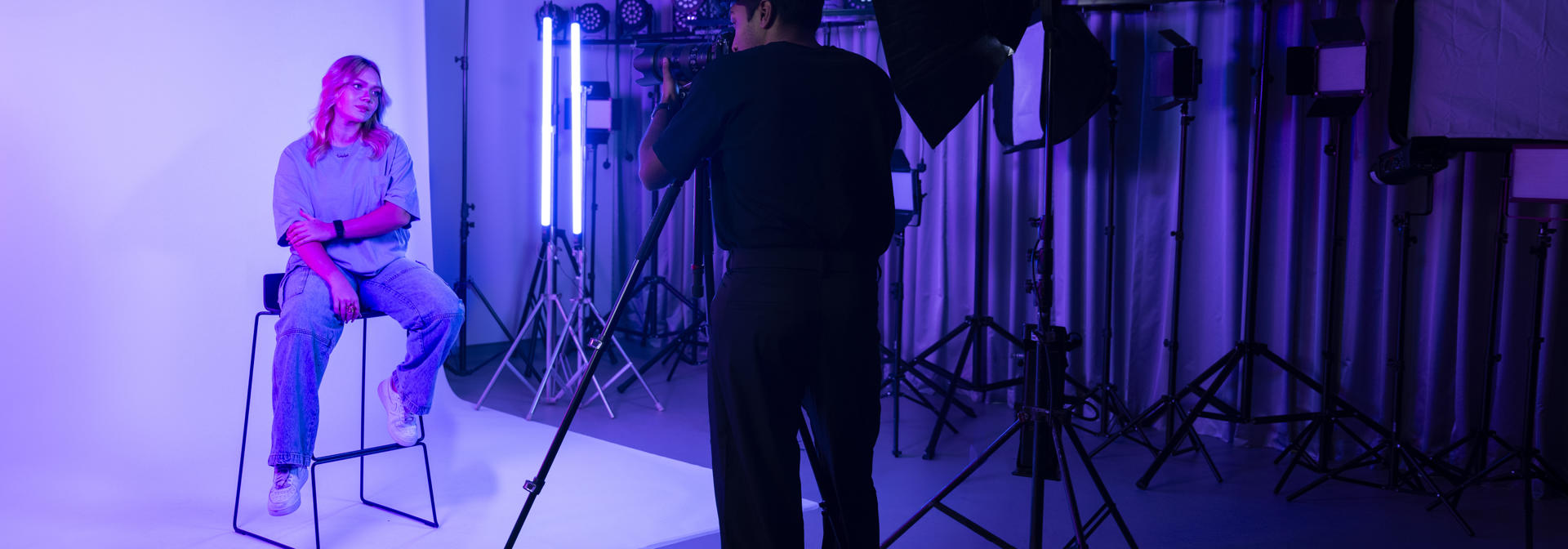 student photographer taking a portrait of model in photography lab