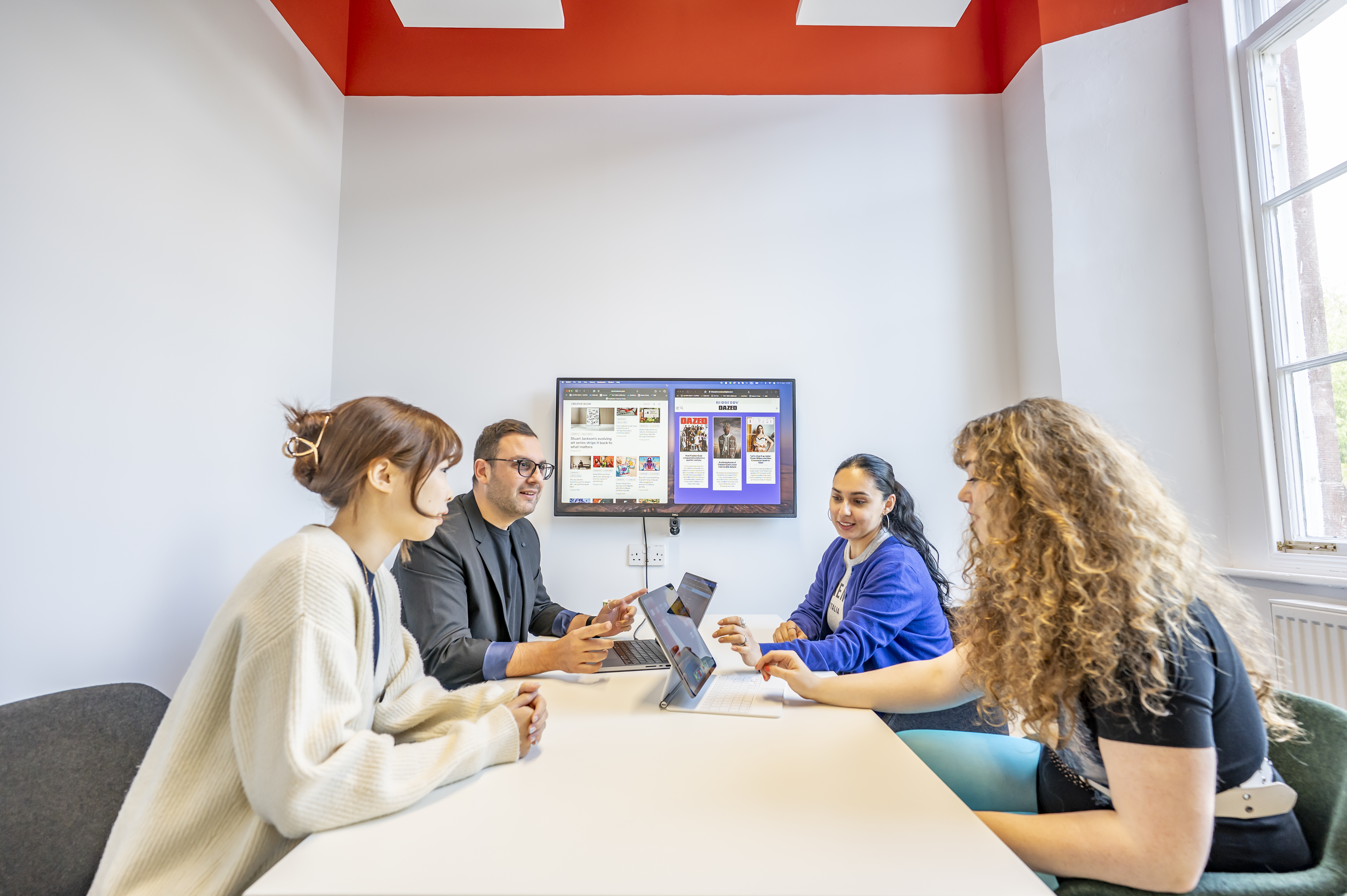 Four students use the meeting room space in the Learning Commons at the Borders Campus