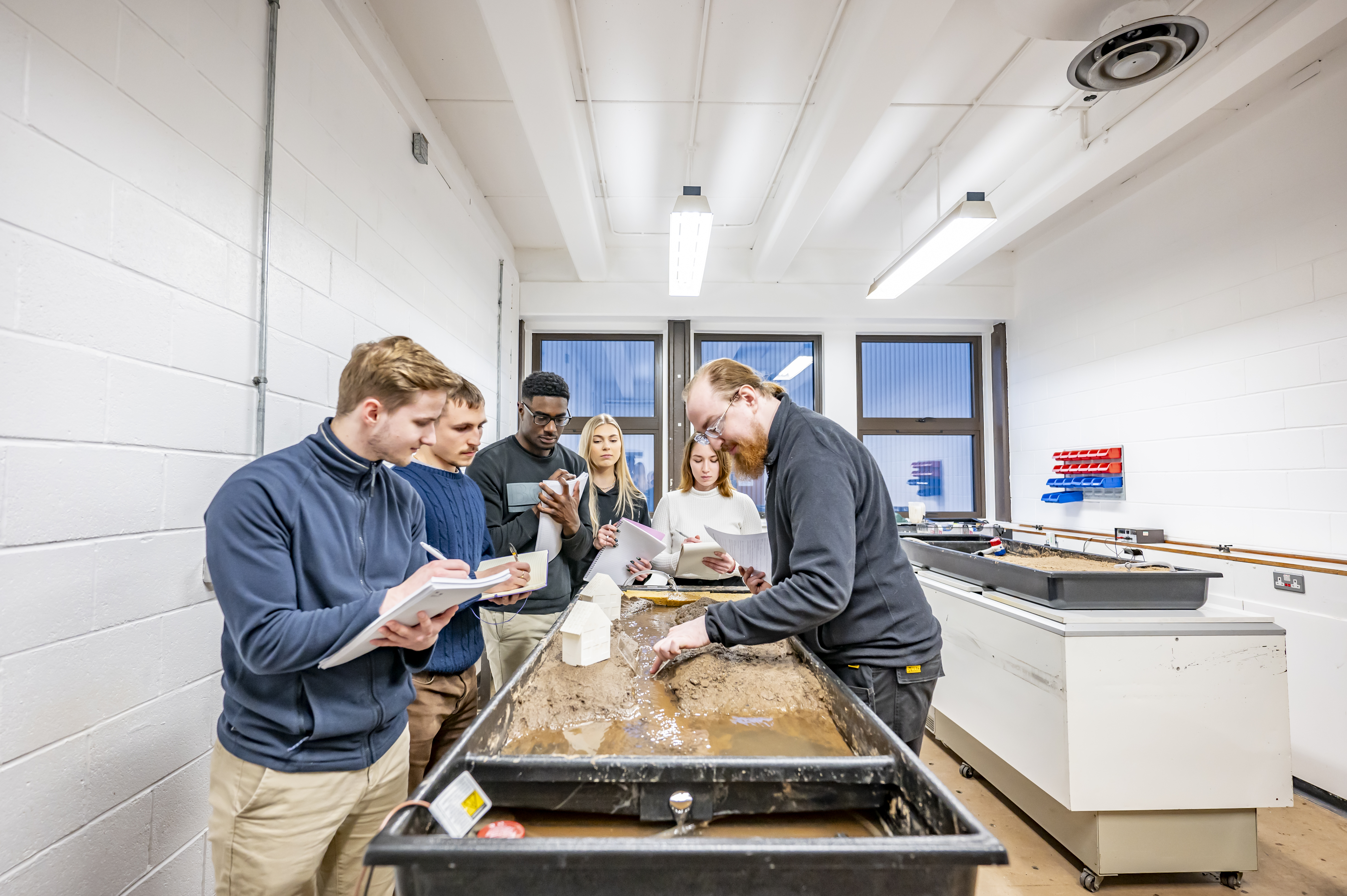 Students in a geography teaching lab getting a demonstration by a lecturer