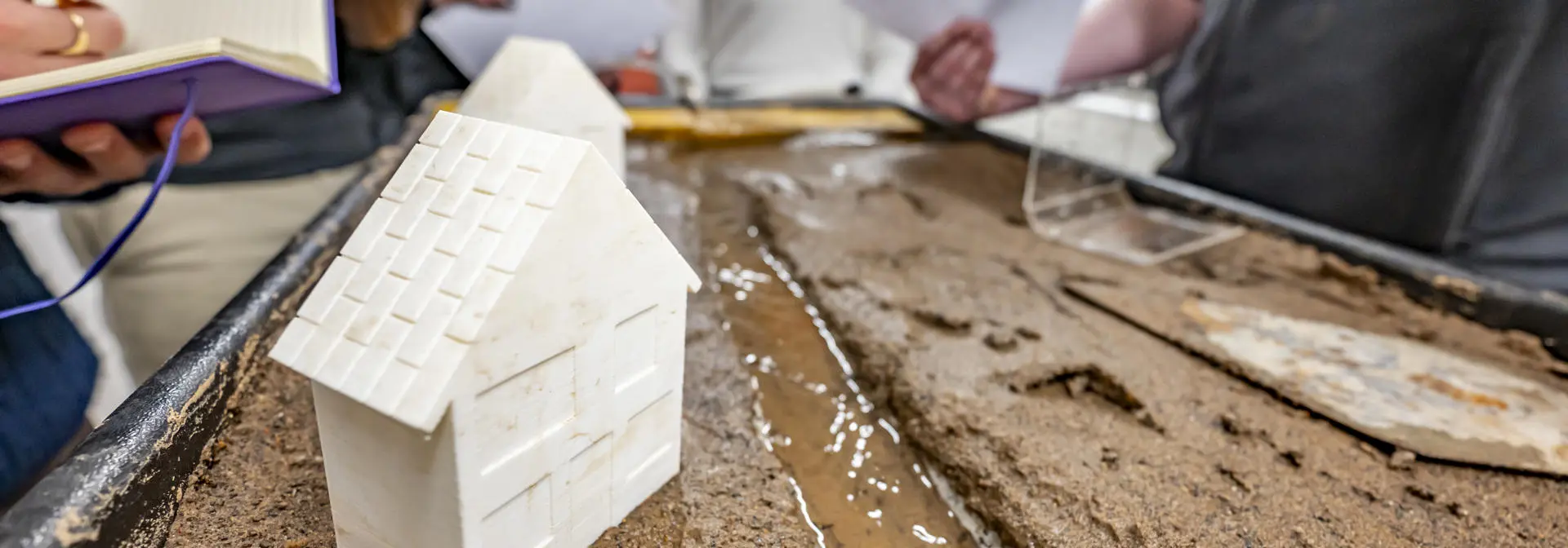 Geography students analysing river meanders in city planning and socio-economic impacts