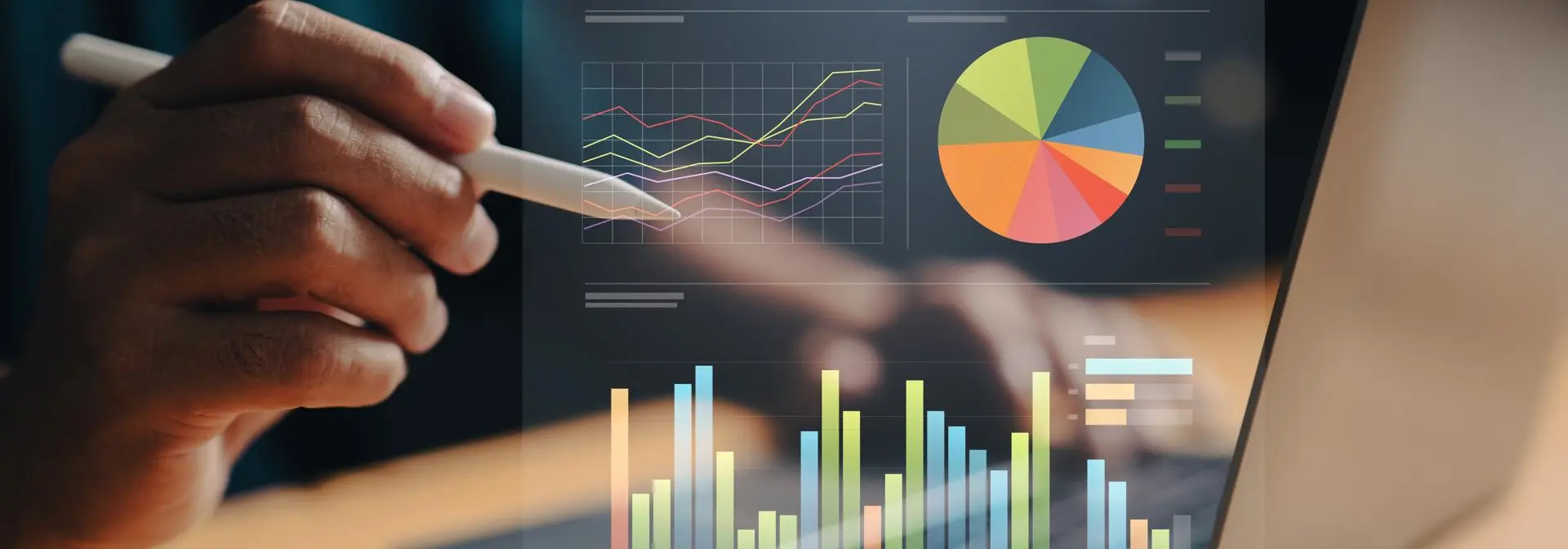 A person using a stylus to interact with a laptop displaying various data visualisations, including graphs and charts.