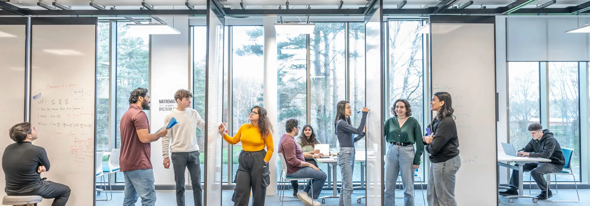 A group of students using the suspended whiteboards in the GRID building