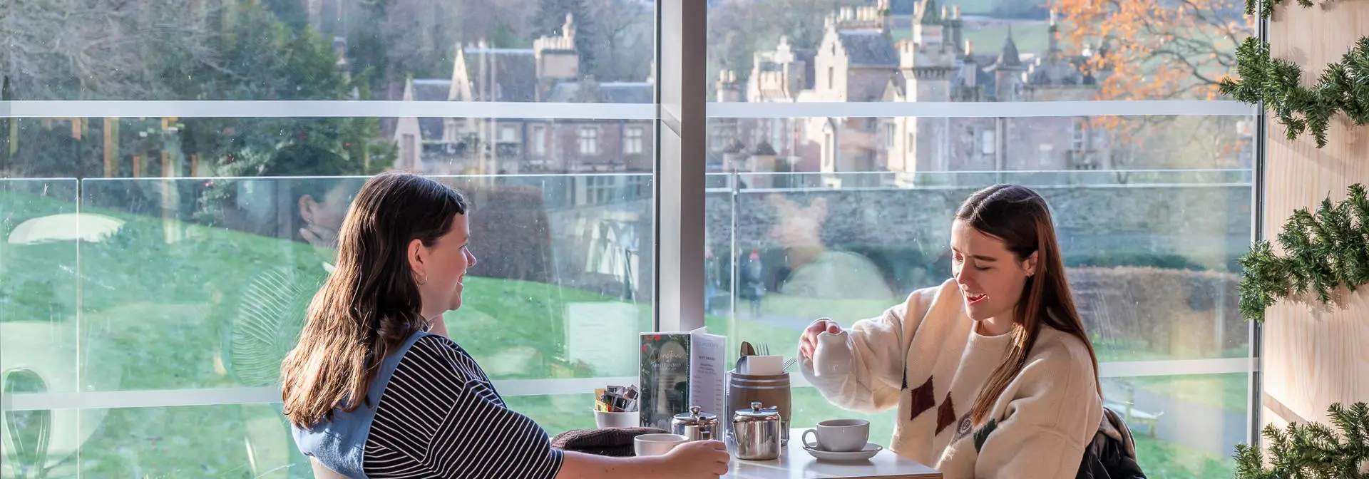 Two people sitting in a cafe drinking tea.