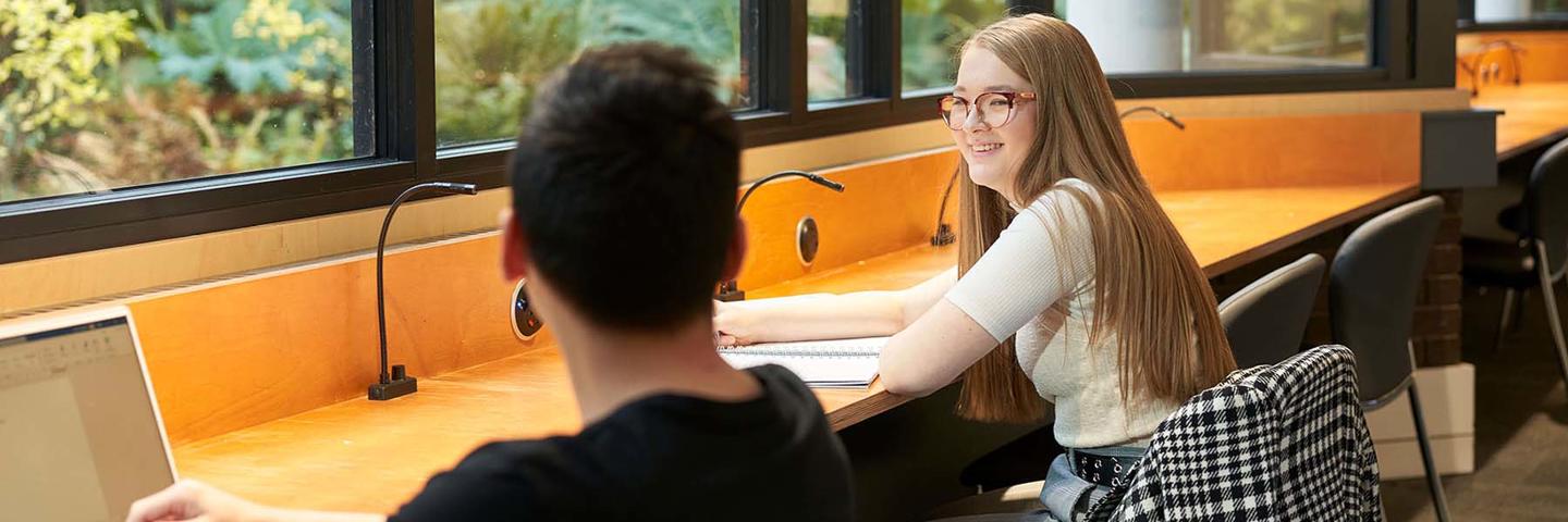 Two students smiling as they work