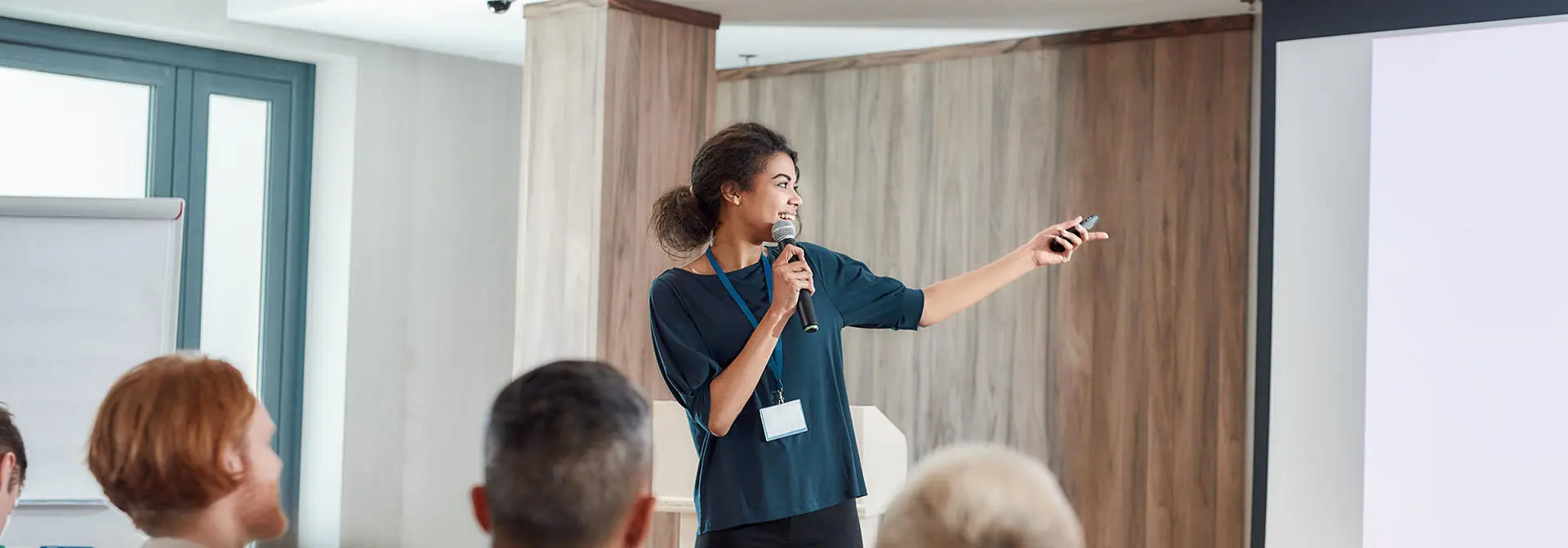 A female lecturer, presenting in front of a group.