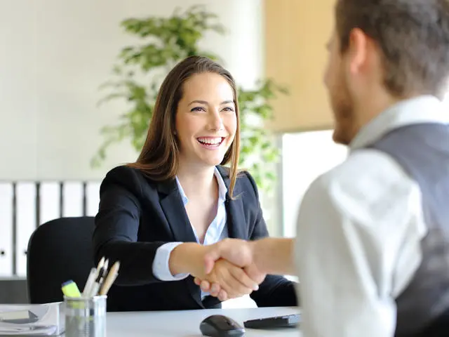 Two individuals shaking hands after a job interview.