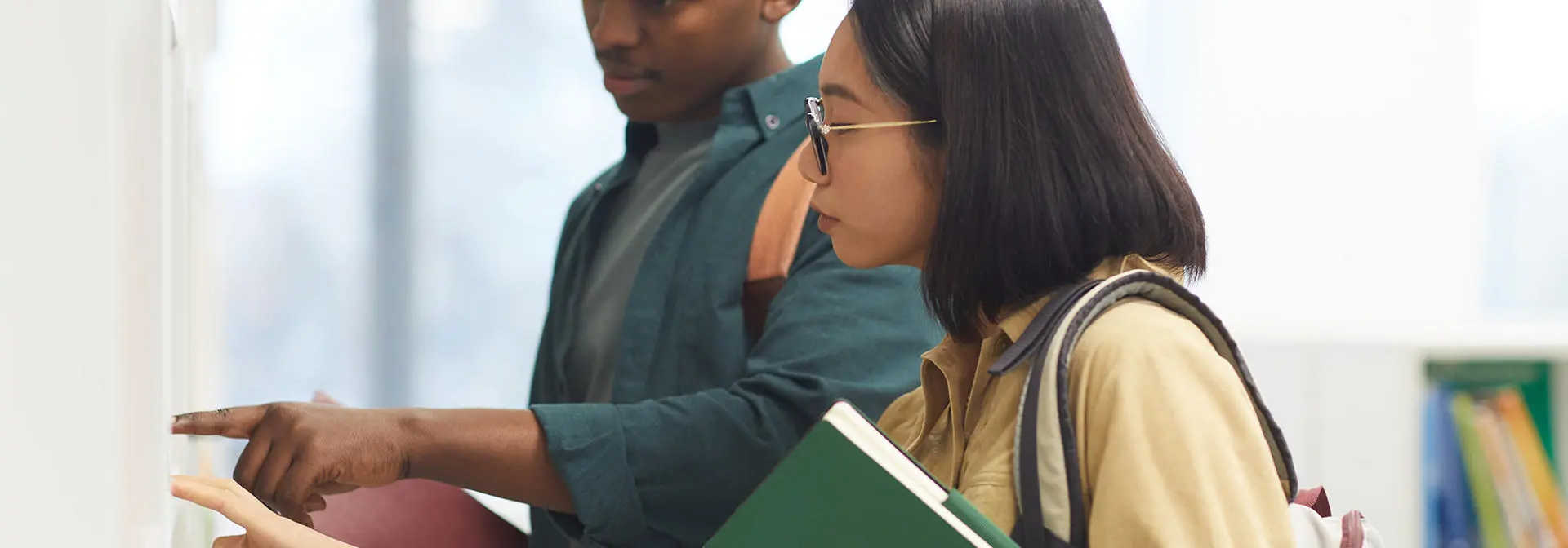 Two students looking at a board together.