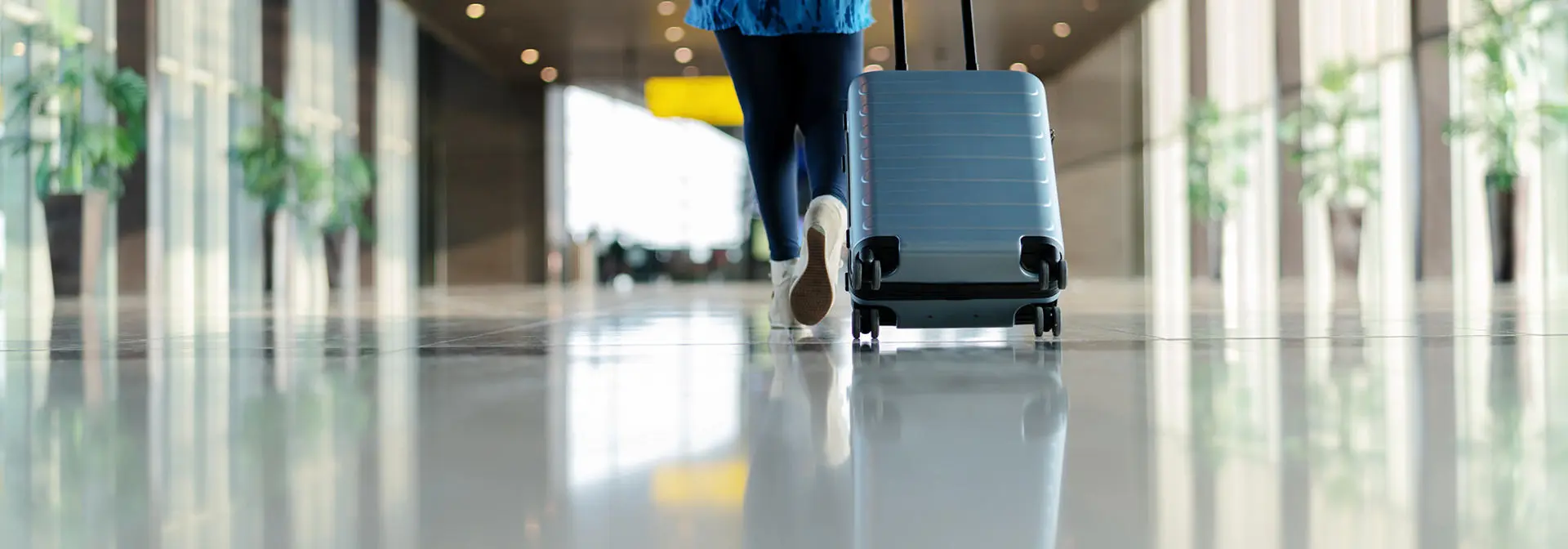 An individual with luggage walking through the airport.