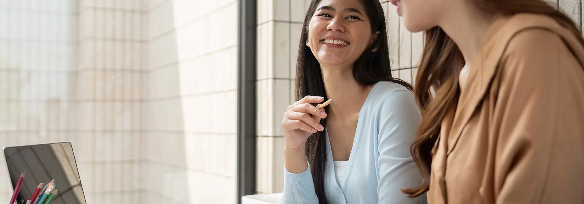 Two students working together and laughing.