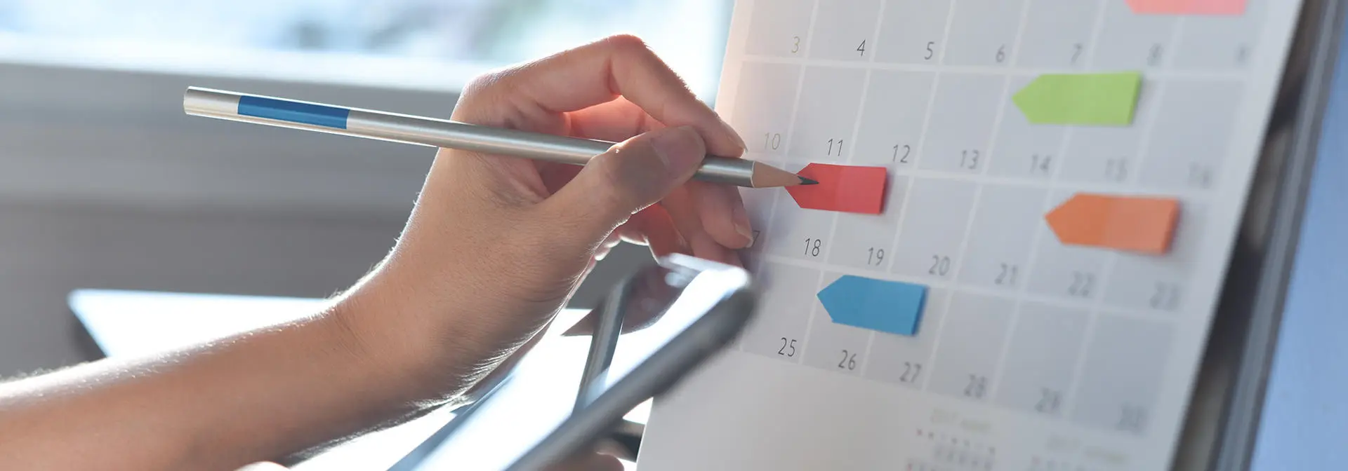 A close up of a hand writing points on a calendar.