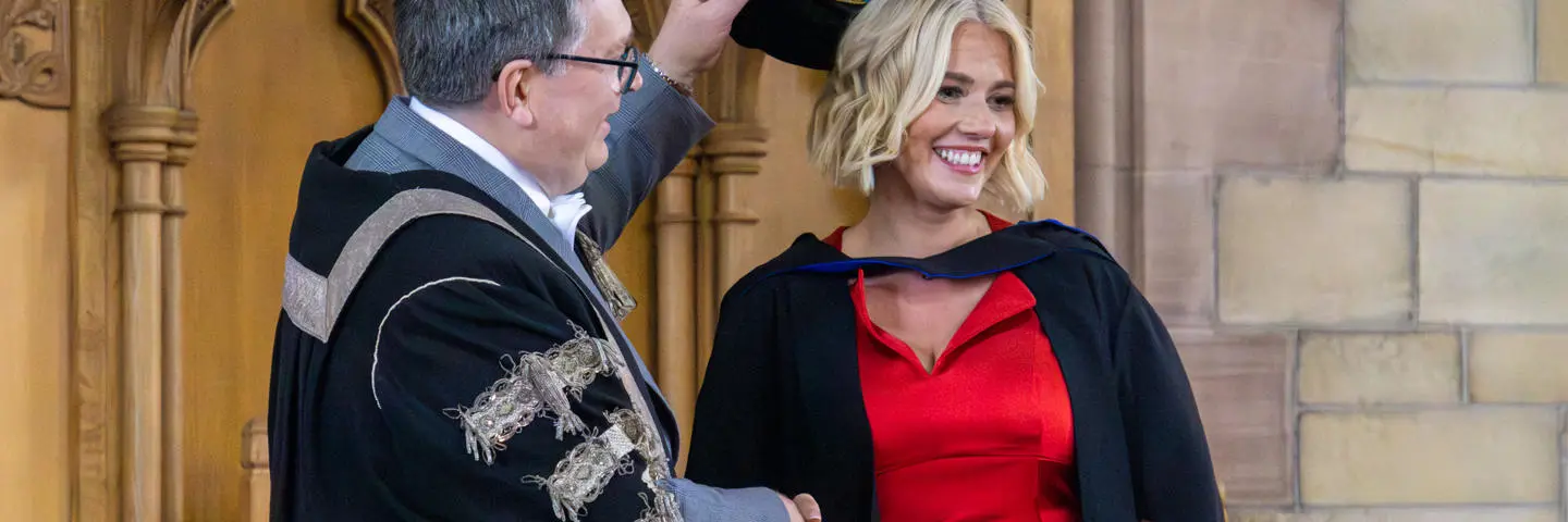 A student shaking hands with the Principal at the graduation ceremony.