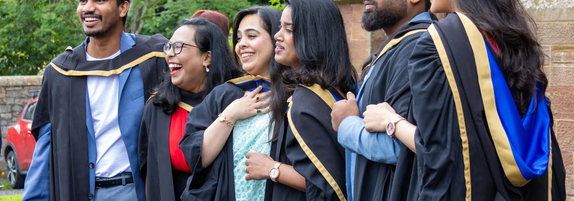 Graduates at the Scottish Borders campus post for photographs outside the ceremony hall.