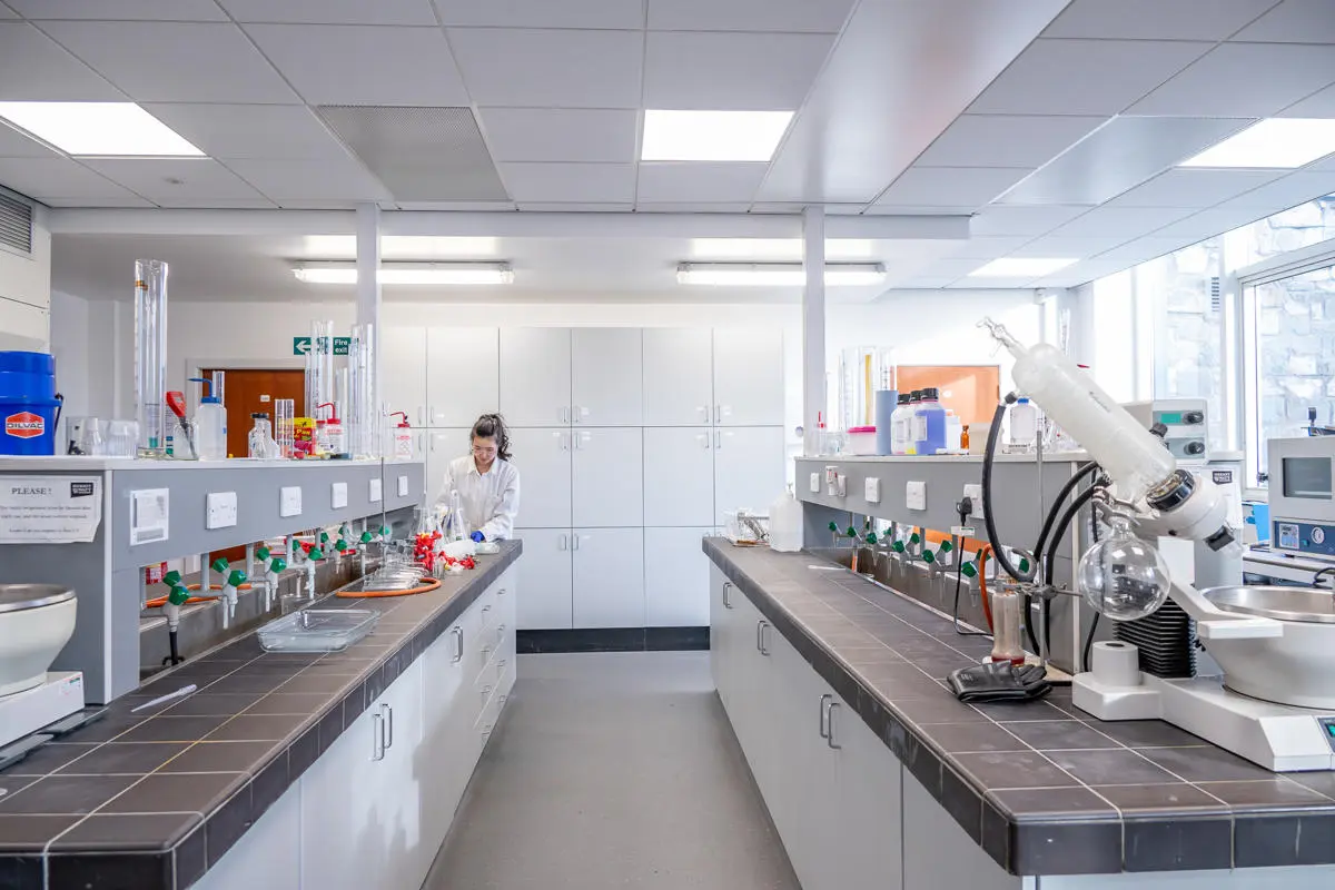 A chemical laboratory with multiple cupboards and equipment on display.