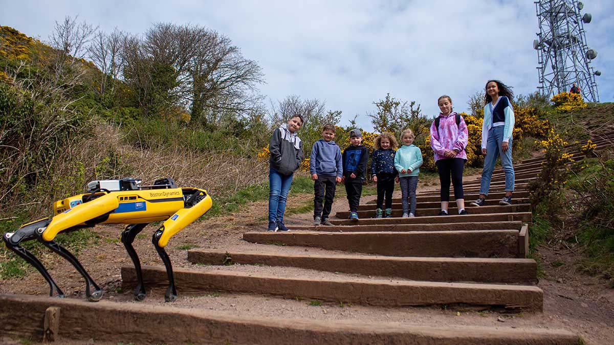Boston Dynamics robot dog climbing steps with children