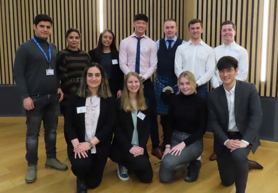 A diverse group of smiling young adults posing for a photo together.